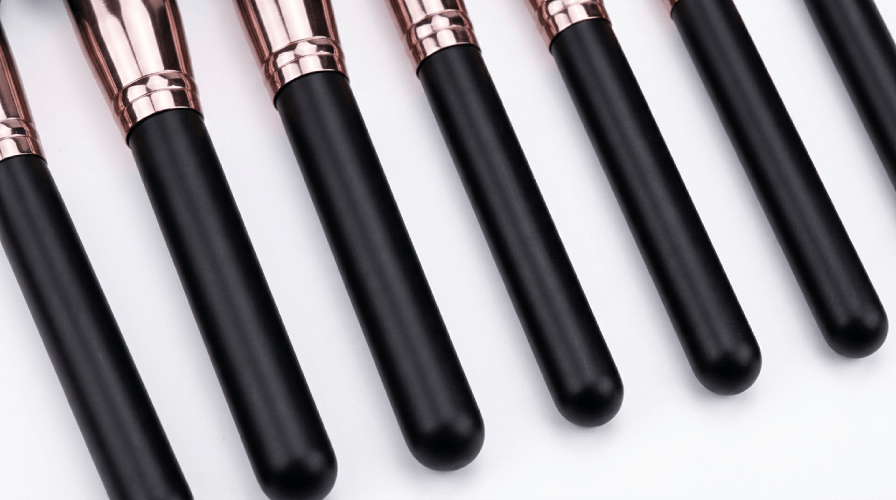 Close-up of durable 7-layer painting wood handles on professional makeup brushes with a matte black finish